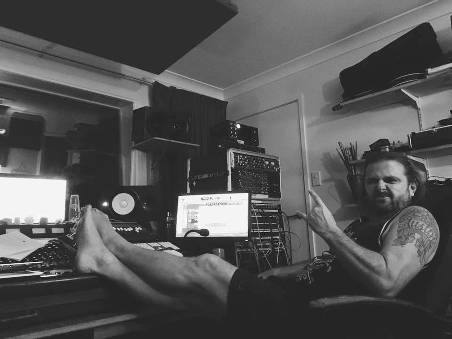A producer relaxing in his home studio, feet up, mid-session
