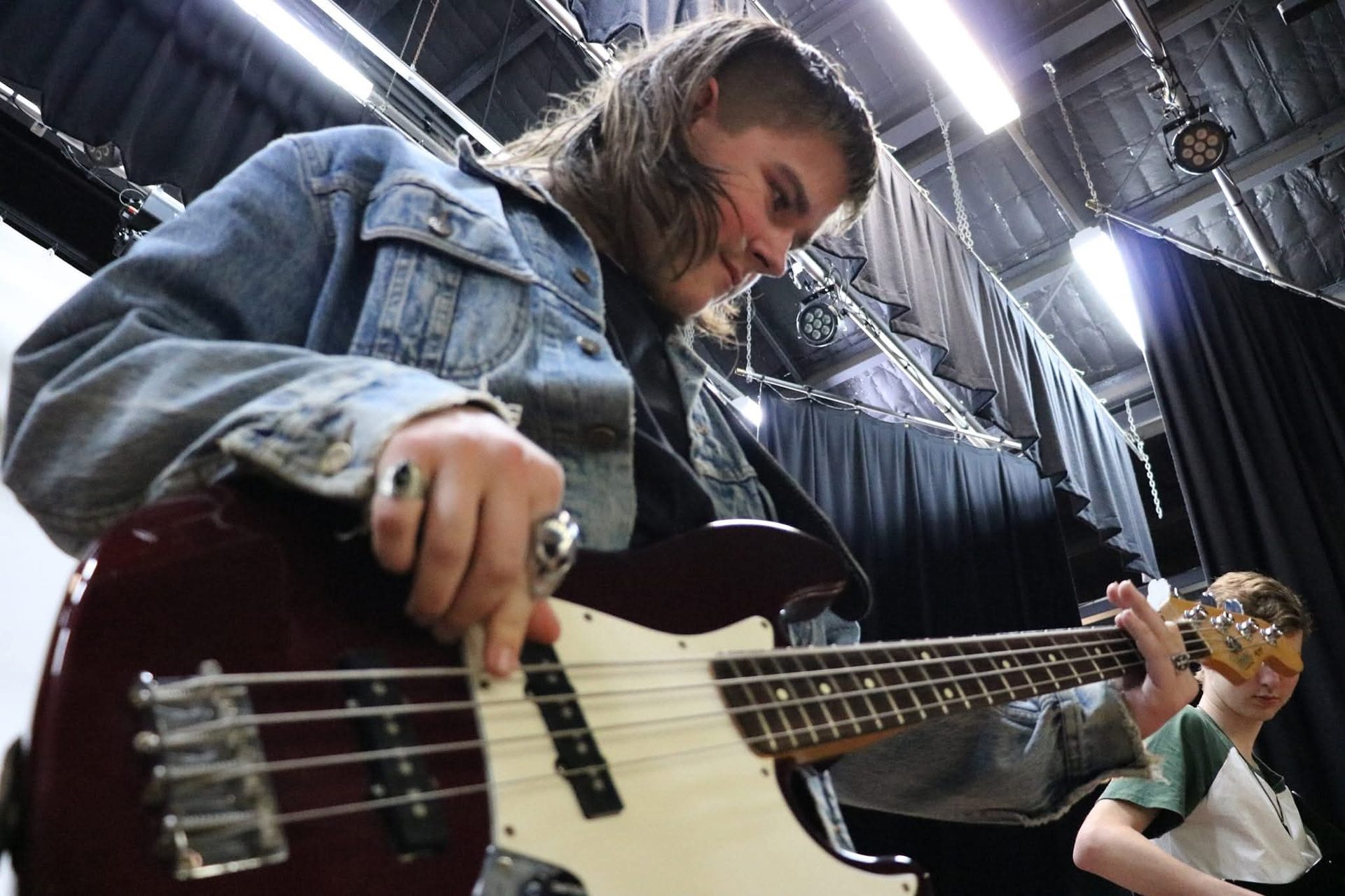 A musician playing bass guitar in a live rehearsal space